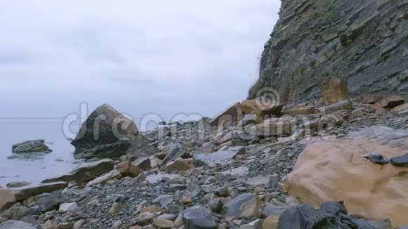 海岸雨天有巨大悬崖的野生石滩视频的预览图