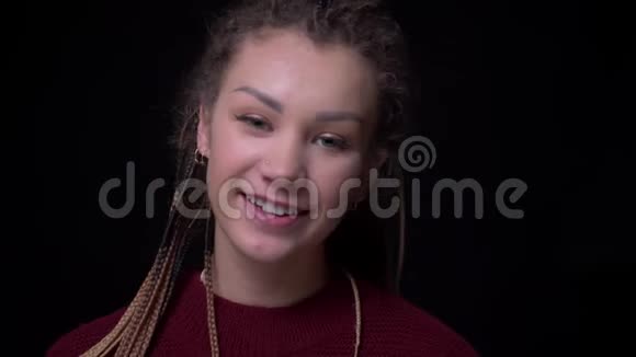 古怪的黑发女孩穿着刺和可怕的微笑快乐和谦卑地进入相机在黑色的背景视频的预览图