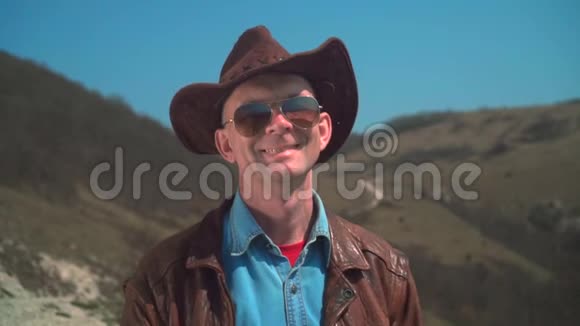 戴牛仔帽皮夹克眼镜的人男人看着相框笑了笑视频的预览图
