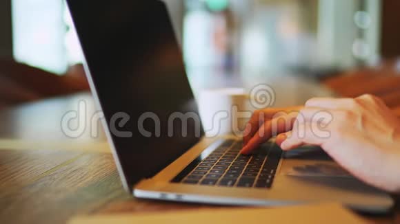 在笔记本电脑键盘和触摸板上打字的老人的特写双手视频的预览图