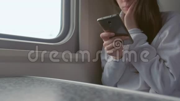 疲惫的年轻女子在火车上用手机看视频双手特写视频的预览图