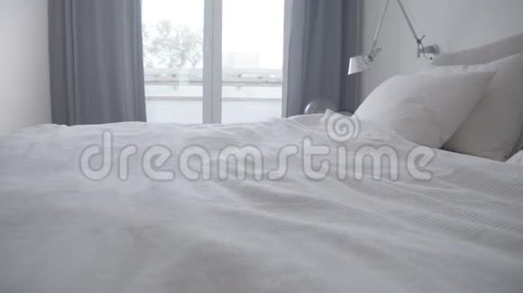 白天女人在家中卧室的床上慢镜头视频的预览图