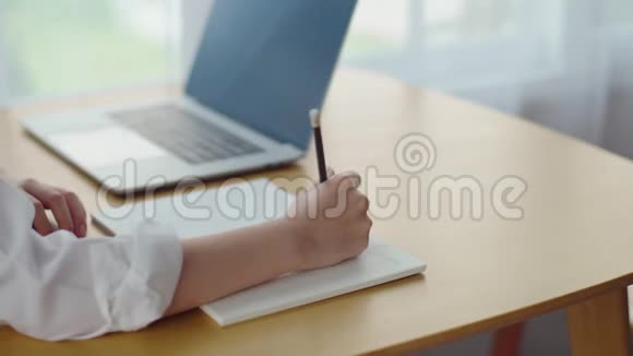 女人用铅笔在笔记本上写字视频的预览图