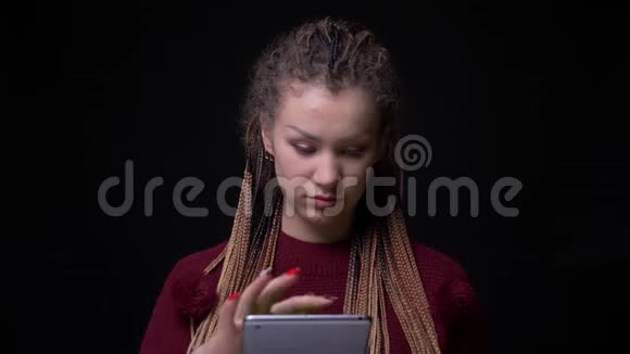 带着恐惧的古怪女孩展示了绿色平板电脑屏幕的喜悦在黑色背景上推荐应用程序视频的预览图