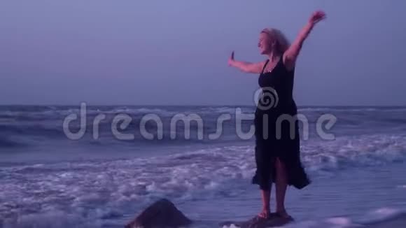 女人开玩笑笑着玩着挥舞着手臂站在石头上浪荡着视频的预览图