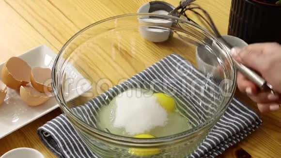 把鸡蛋和糖放在玻璃碗里视频的预览图