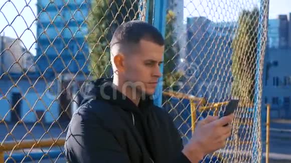 城市风格肖像男子使用智能手机享受城市网栅背景英俊自信的生活方式视频的预览图