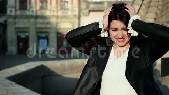 疲倦的女人头痛心烦意乱的女孩在街上用手摸头的肖像视频的预览图