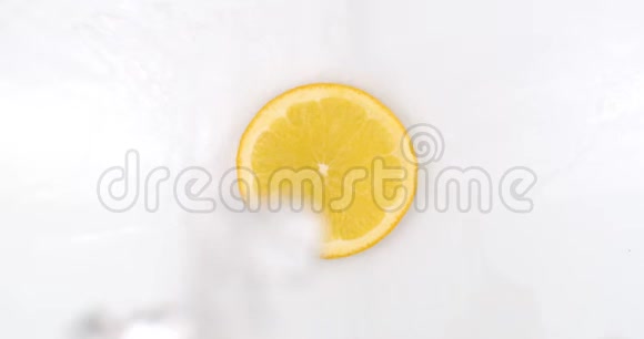 俯视图在白色的背景上一个新鲜的橘子躺在水里水滴从上面落下溅起视频的预览图