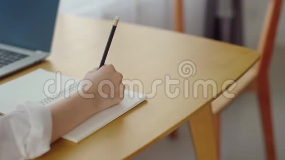 女人用铅笔在笔记本上写字视频的预览图