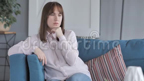坐在沙发上的穿着便便的女孩思考视频的预览图