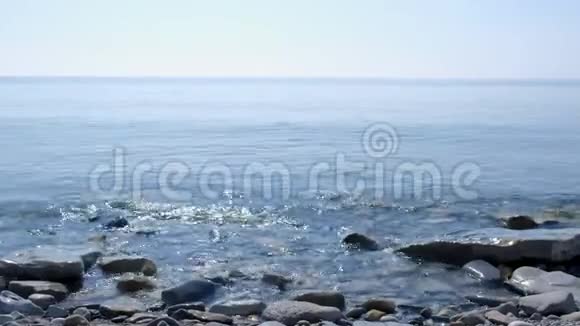 海景海岸线海滨阳光明媚有巨大的鹅卵石和波浪视频的预览图