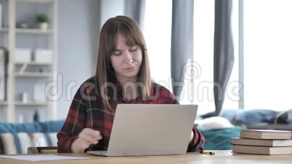 在手提电脑上工作的谄媚的流浪少女视频的预览图
