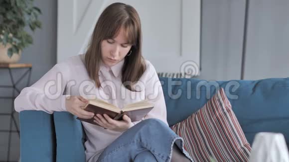 坐在沙发上的女孩读书视频的预览图