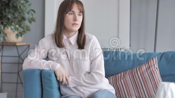 家里坐在沙发上的休闲女孩视频的预览图