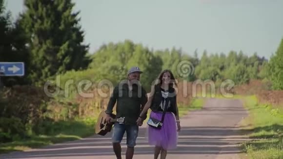 两个情人和一个女孩在乡间小路上那家伙拿着吉他他们玩得很开心交流得很好视频的预览图