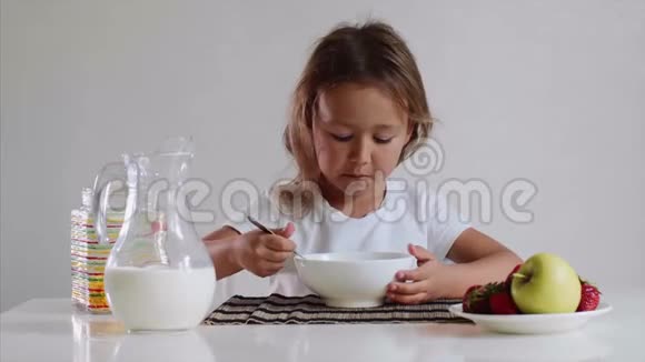 小可爱的小女孩用牛奶快乐地吃玉米片视频的预览图