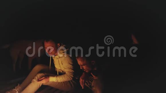 一群朋友晚上在海边的篝火旁玩快速视频慢动作4k视频的预览图