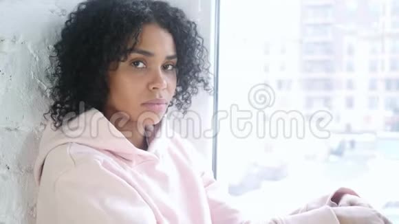 安静点年轻的非洲女人手指在嘴唇上坐在窗前视频的预览图