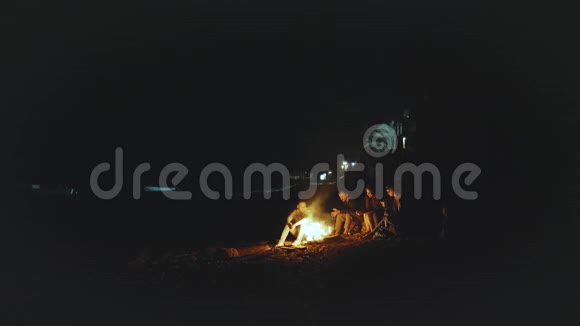 一群朋友晚上在海边的篝火旁玩快速视频慢动作4k视频的预览图