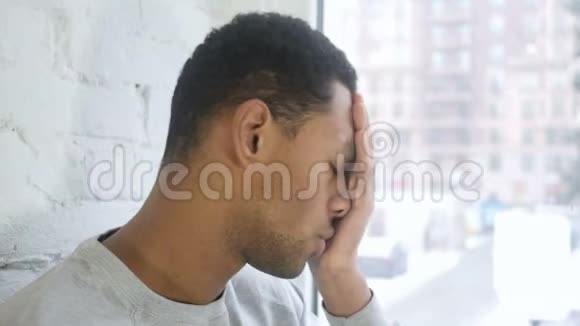 关上头痛的美国黑人青年窗户视频的预览图