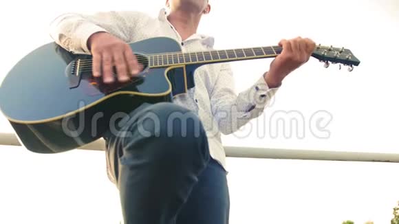 男人弹吉他吉他手在触摸吉他弦从底部看中弹视频的预览图