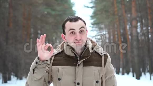 穿着夹克的帅哥的肖像在镜头前显示了良好的姿态人站在冬林中视频的预览图