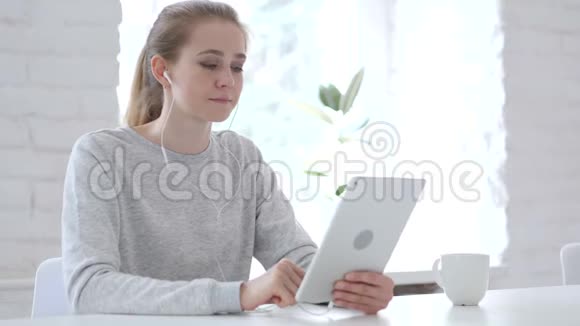 在平板电脑上进行网上视频聊天时放松年轻女子的谈话视频的预览图