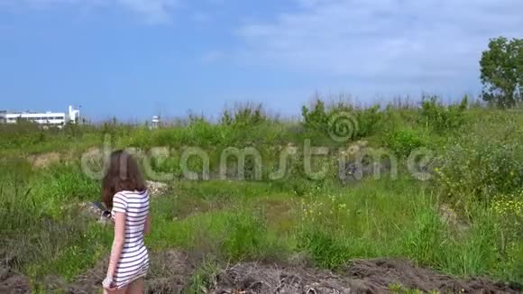 在度假村附近的灌木丛中行走的年轻女子视频的预览图
