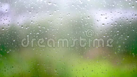 窗玻璃上的雨滴背景模糊慢动作视频的预览图