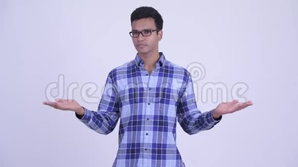 快乐年轻的印度时髦男人比较某种东西视频的预览图