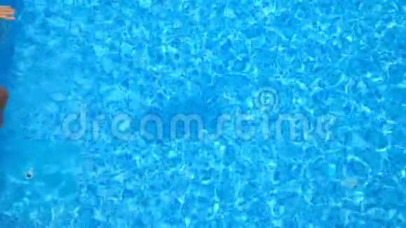 年轻女子跳在游泳池里溅出晶莹剔透的水花令人难以辨认的女孩在休息和娱乐视频的预览图
