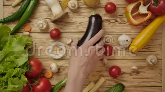 面无表情的厨师从木制桌子上拿走茄子视频的预览图