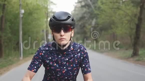 迷人的因果女孩开始骑自行车把注意力集中在自行车上骑自行车的女孩戴着头盔和眼镜慢动作视频的预览图