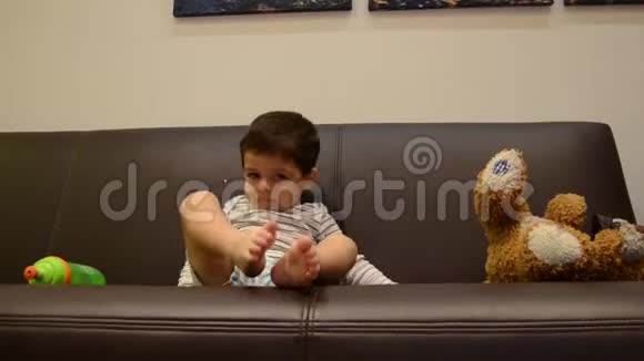 可爱的两岁男孩和他的泰迪熊看电视把泰迪放在适当的位置视频的预览图