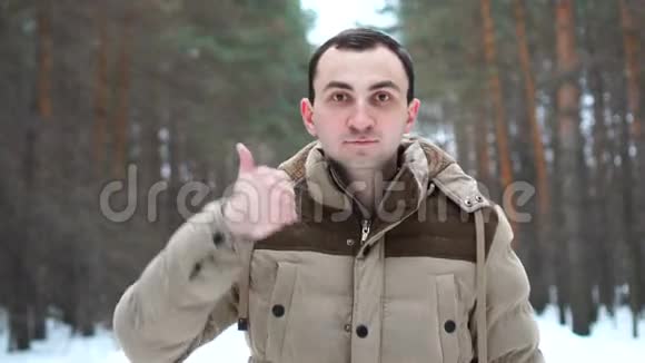 穿着夹克的人的画像显示了拇指人站在冬林中视频的预览图