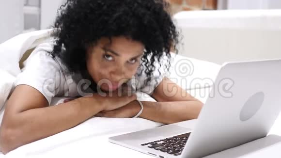 快乐的美国黑人妇女趴在床上竖起大拇指视频的预览图