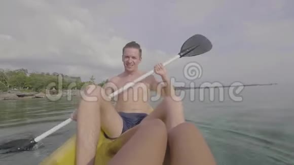 年轻的白种人喜欢在夏天在热带度假胜地的海洋中划艇视频的预览图