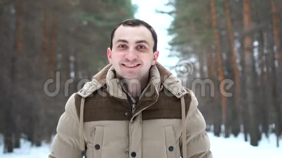 一个穿夹克的人点头表示赞同某件事的肖像人站在冬林中视频的预览图