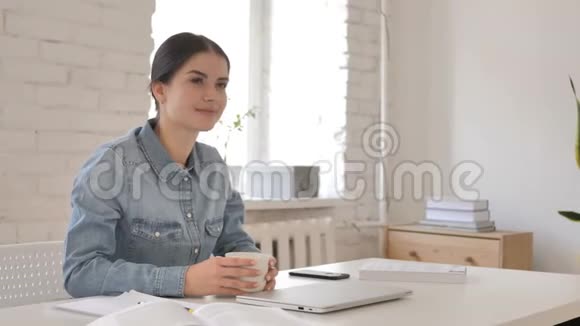 年轻女孩在创意工作场所喝咖啡视频的预览图