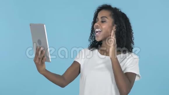 非洲女孩通过蓝底平板电脑进行视频聊天视频的预览图