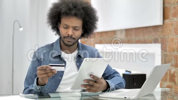 非洲男子在桌上的网上购物视频的预览图