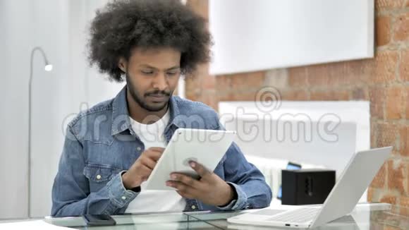 非洲男人在桌上进行在线视频聊天视频的预览图