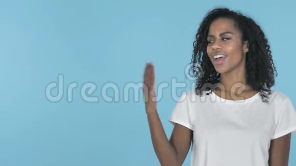 非洲女孩展示产品在侧面蓝色背景视频的预览图