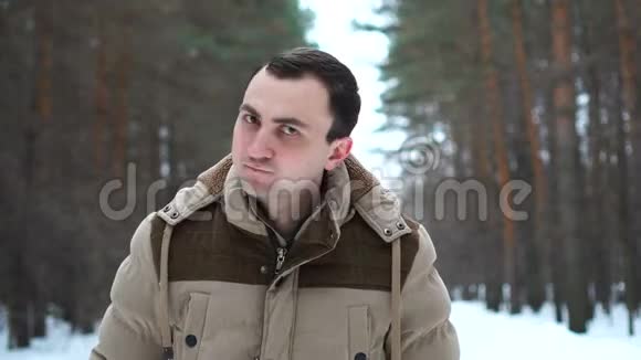 穿夹克衫的人点头拒绝某物的肖像人站在冬林中视频的预览图