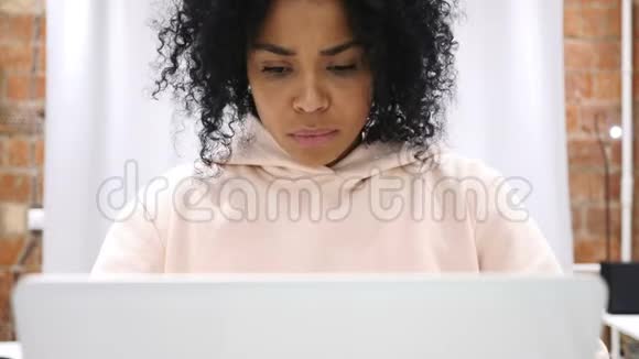 疲惫的非裔美国妇女在笔记本电脑上工作时试图放松视频的预览图