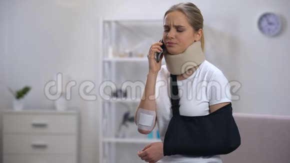 戴泡沫颈项圈和手臂吊带的被解雇的女人在打电话坏消息视频的预览图