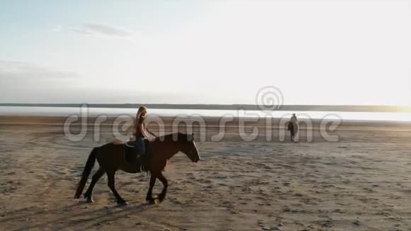 无人驾驶鸟瞰妇女骑马开放海岸拖延训练慢跑视频的预览图