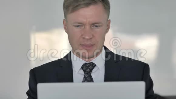 在笔记本电脑上工作的带头疼的贴身商人视频的预览图