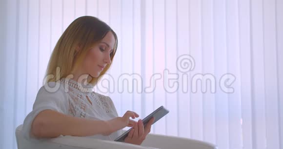 特写侧景照片年轻漂亮的白种人女商人用平板电脑笑着开心地看着镜头视频的预览图